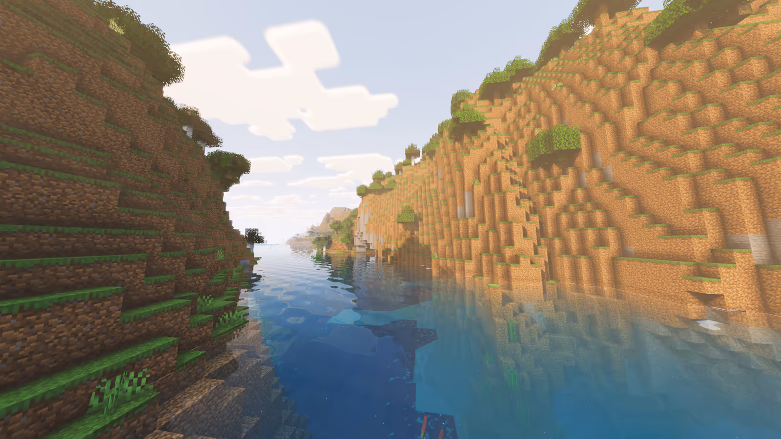A river between steep grass and stone hills